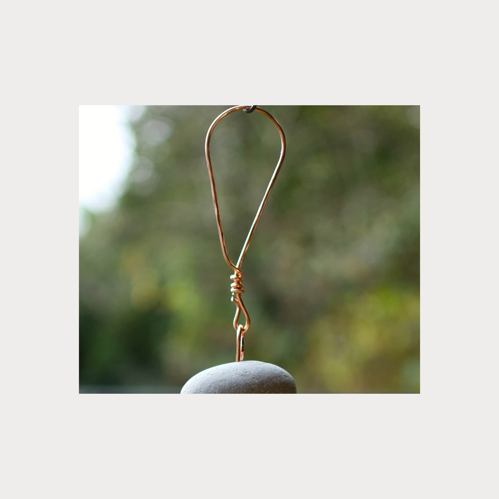 Copper hook on a stone with a blurred natural background