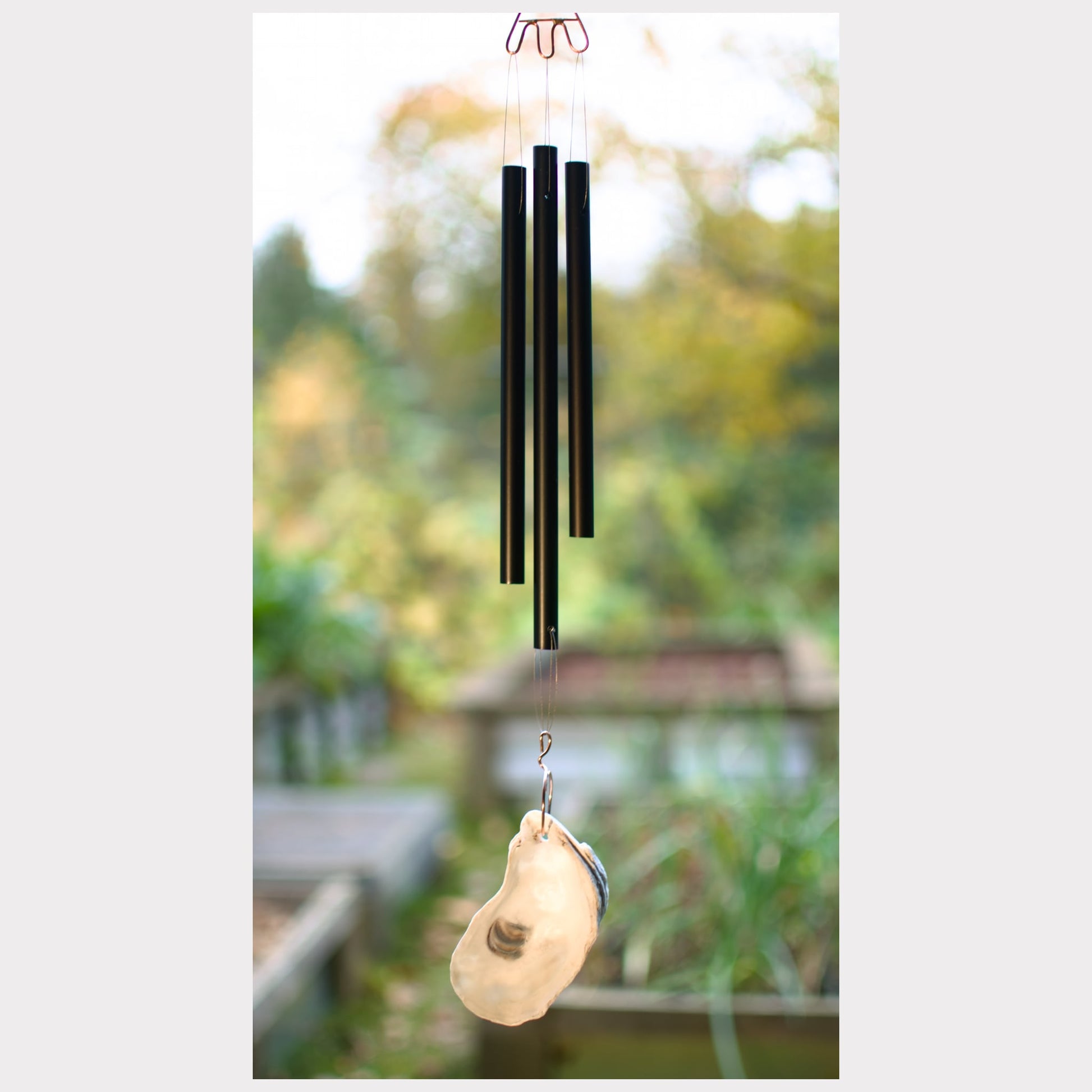 Black aluminum chimes with an oyster half shell windsail.