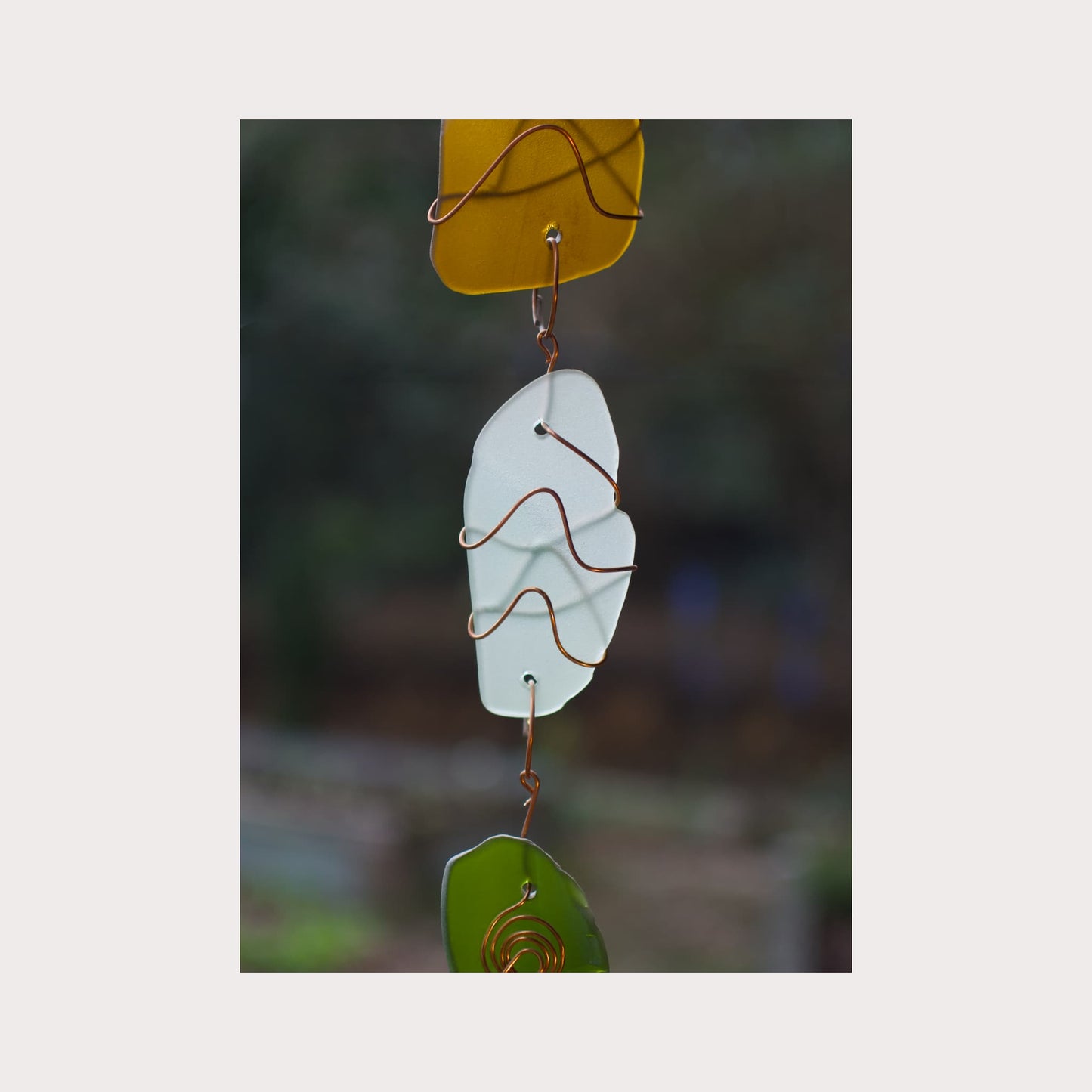 Decorative glass hanging with a blurred natural background