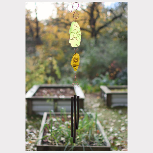 Decorative wind chime with colorful stones against a garden background
